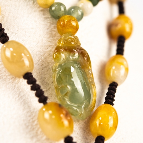 17 - VARIEGATED JADE NECKLACE formed of 73 SMALL BEADS suspending a CARVED VARIEGATED BROWN shading to GR... 