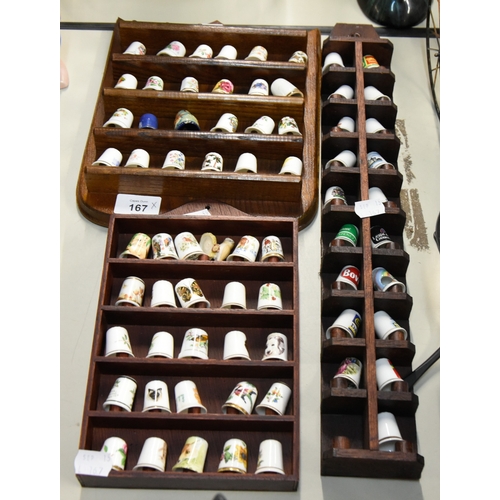 THREE WOODEN WALL RACKS DISPLAYING A COLLECTION OF 69 CERAMIC THIMBLES