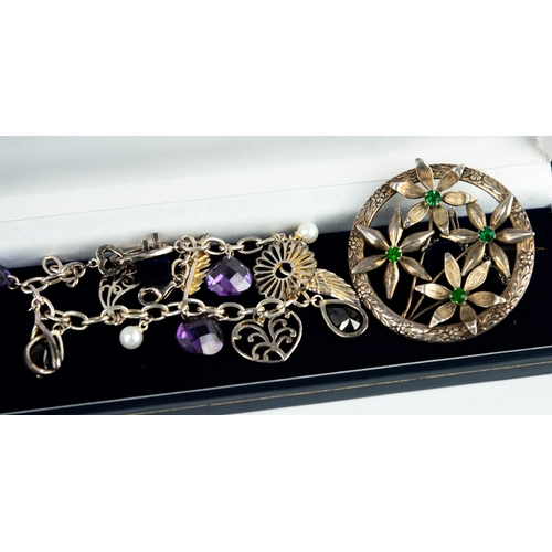 129 - STERLING SILVER LARGE OPENWORK CIRCULAR BROOCH with four large flowers, each centred by a green ston... 