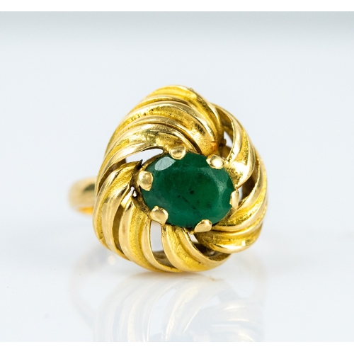 91 - GOLD COLOURED METAL RING claw set with an oval emerald with a broad whirl pattern surround (tests 18... 