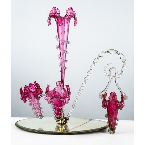 76 - VICTORIAN CRANBERRY AND CLEAR GLASS TABLE CENTRE EPERGNE, the oval mirrored base with central gilt m... 