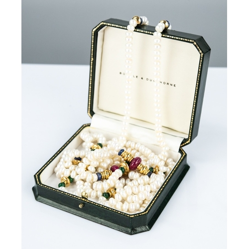 128 - A LONG SINGLE STRAND NECKLACE OF UNIFORM CULTURED PEARLS with gold plated reel shaped dividers flank... 
