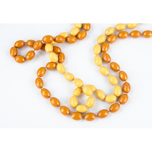 152 - A LONG TWO STRAND NECKLACE of yellow and pink amber