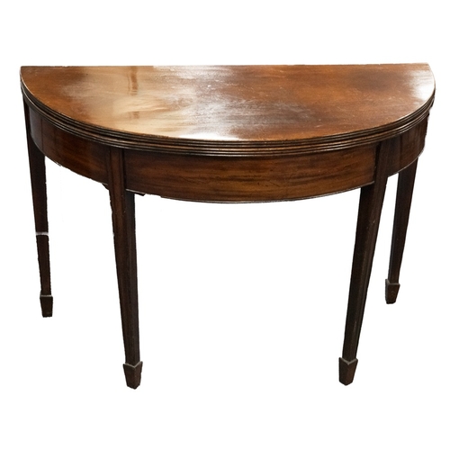 79 - GEORGE III DEMI-LUNE FIGURED MAHOGANY CARD TABLE, the fold over top enclosing a polished interior, s... 