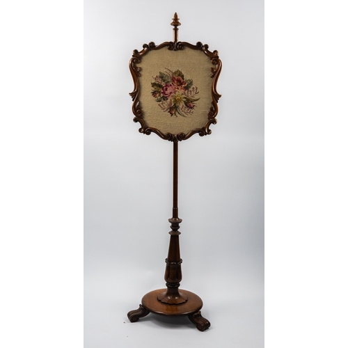 85 - WILLIAM IV CARVED ROSEWOOD POLE SCREEN, the floral woolwork panel housed in a scroll carved frame an... 