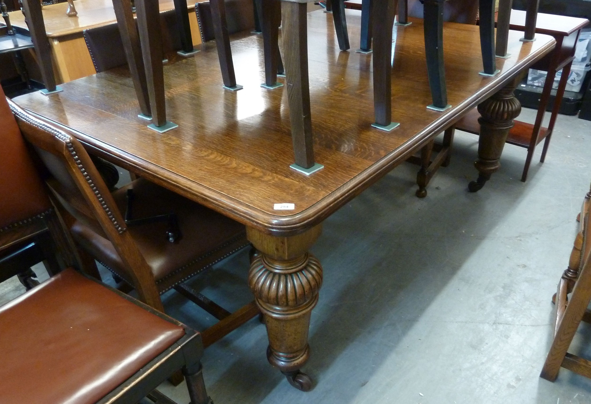 A LARGE OAK WIND-OUT EXTENDING TABLE, HAVING TWO ADDITIONAL LEAVES ...