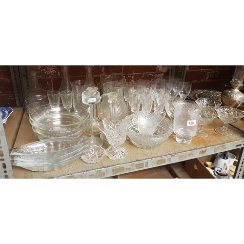 128 - SHELF WITH QTY OF GLASS DECANTERS, FRUIT BOWLS, JUGS, WINE GLASSES & A PAIR OF GLASS CANDLE STICKS