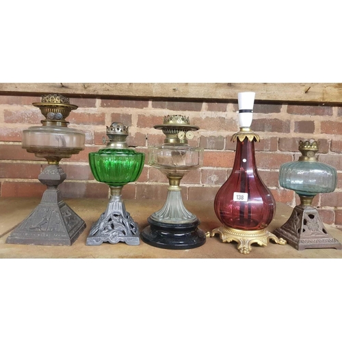 138 - 4 OIL LAMPS WITH GLASS RESERVOIRS & 1 CRANBERRY COLOURED GLASS TABLE LAMP