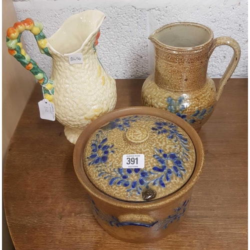 391 - CLARICE CLIFF WATER JUG A/F , A POTTERY WATER JUG & A POTTERY POT WITH LID