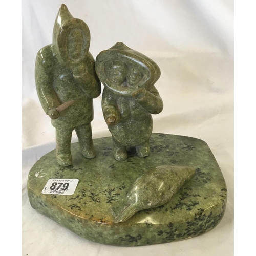 879 - A GREEN SOAPSTONE INUIT CARVING ON BASE WITH 2 FIGURES & A SEAL