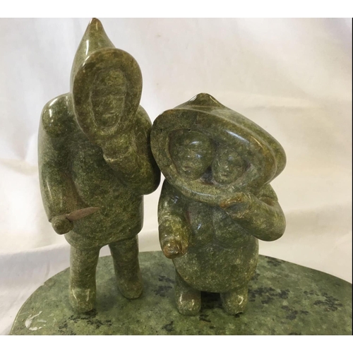 879 - A GREEN SOAPSTONE INUIT CARVING ON BASE WITH 2 FIGURES & A SEAL