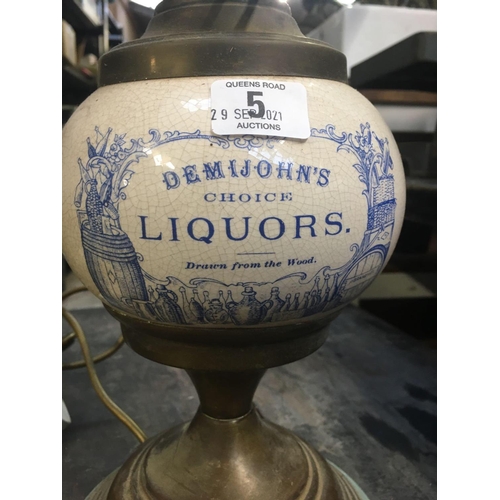 5 - VINTAGE OIL LAMP CONVERTED TO ELECTRICITY WITH CHINA RESERVOIR WITH NAME DEMIJOHNS CHOICE LIQUORS