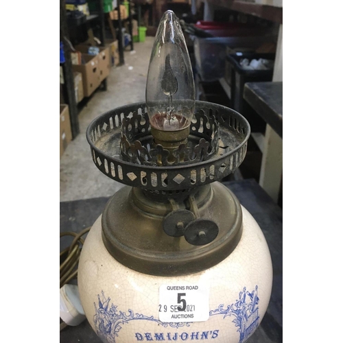 5 - VINTAGE OIL LAMP CONVERTED TO ELECTRICITY WITH CHINA RESERVOIR WITH NAME DEMIJOHNS CHOICE LIQUORS