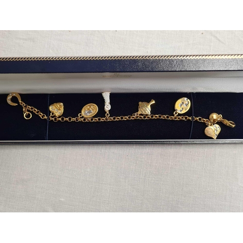 692 - YELLOW & METAL BRACELET WITH A NUMBER OF YELLOW METAL CHARMS