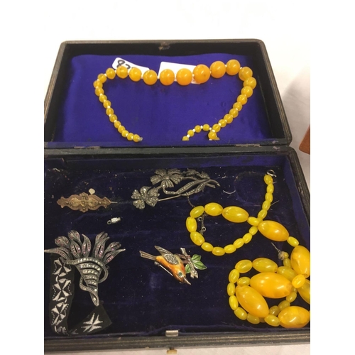 822 - BOX OF BADGES, CANTILEVER JEWELLERY BOX & CONTENTS, YELLOW BEAD NECKLACE ETC