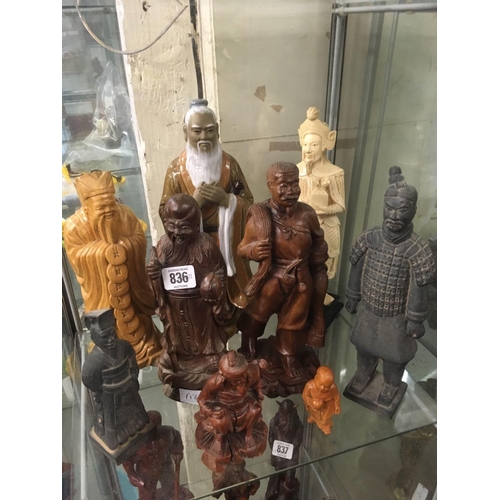 836 - 9 STANDING ORIENTAL FIGURES FASHIONED IN WOOD, POTTERY & RESIN