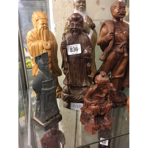 836 - 9 STANDING ORIENTAL FIGURES FASHIONED IN WOOD, POTTERY & RESIN