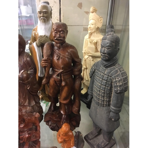 836 - 9 STANDING ORIENTAL FIGURES FASHIONED IN WOOD, POTTERY & RESIN