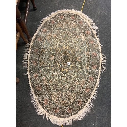 420 - OVAL GREEN GROUND WOOLLEN RUG WITH TASSELED BOARDER