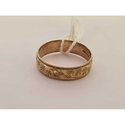 580 - A 9ct GOLD WEDDING BAND WITH CHASED DECORATION, SIZE 'N'