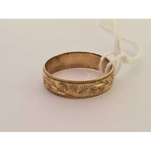 580 - A 9ct GOLD WEDDING BAND WITH CHASED DECORATION, SIZE 'N'