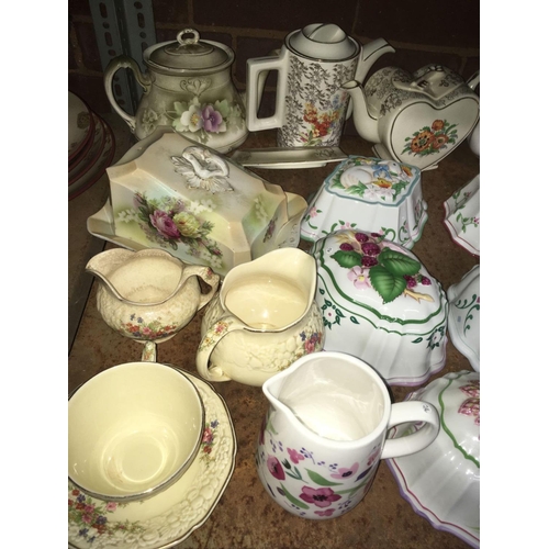 192 - SHELF WITH MISC TEA POTS, JELLY MOULDS, CHEESE DISH & AN EMPTY BELL'S DECANTER