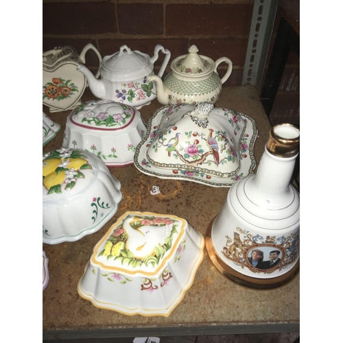 192 - SHELF WITH MISC TEA POTS, JELLY MOULDS, CHEESE DISH & AN EMPTY BELL'S DECANTER