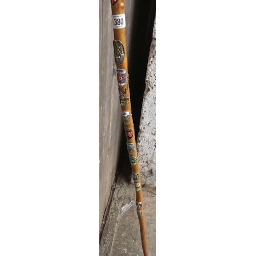 380 - WOODEN HIKING STICK WITH HORN HANDLE & QTY OF TOWN BADGES ATTACHED