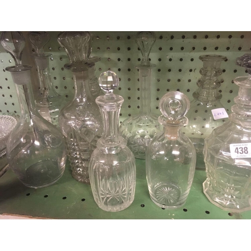 438 - SHELF OF GLASS DECANTERS & STOPPERS