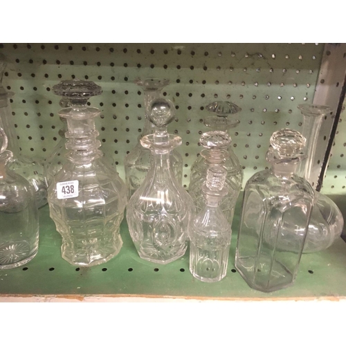 438 - SHELF OF GLASS DECANTERS & STOPPERS