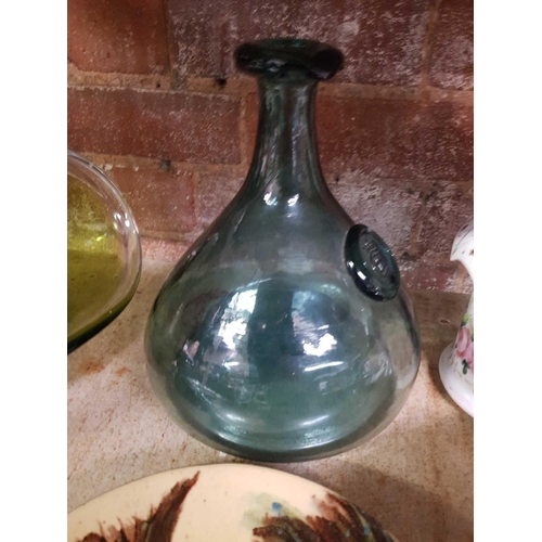 198 - SHELF WITH MISC DECORATIVE GLASS & PLATES & A GLASS SHIP'S DECANTER STYLE BOTTLE MARKED CE