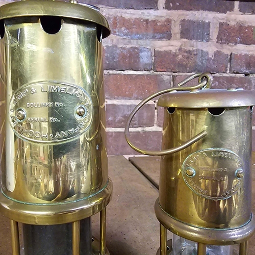 179 - 2 BRASS MINERS LAMPS, 8.5'' & 6.5'' TALL. TALL ONE MARKED YSTRAD MYNACH COLLEGE SILVER JUBILEE 1959 ... 