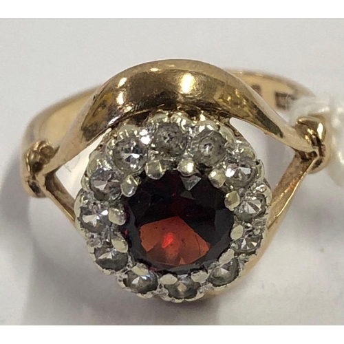 643 - A RED STONE CIRCULAR CLUSTER RING SET IN 9ct, SIZE 'J', 3.4g