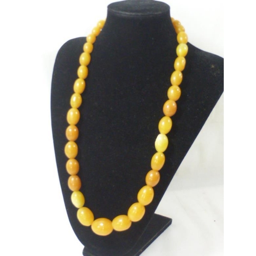 56 - A 1920s butterscotch Bakelite amber bead necklace of progressing oval beads (Tested With Simichrome)... 