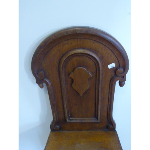 578 - A Victorian oak hall chair, the carved panelled back with swan neck pediment, solid seat and taperin... 