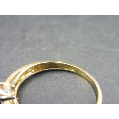 406 - Hallmarked Gold 375 Ring with Raised Solitare set in Diamante Band (Size O) Complete with Presentati... 