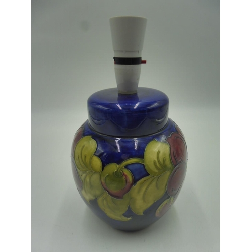 53 - MOORCROFT; a tubeline decorated anemones pattern lamp base on blue ground with impressed marks to ba... 