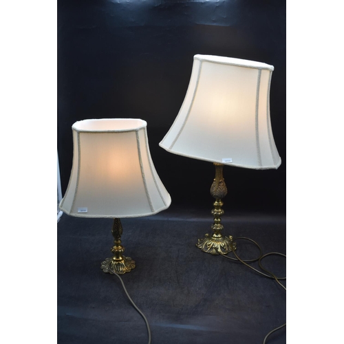 582 - Pair of Cast Brass Table Lamps with ivory colour shades. 1 x  approx 60cm tall 1 x approx 40cm tall.