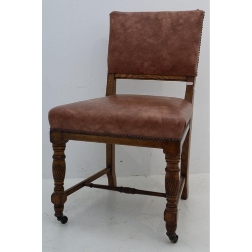 12 - Antique Oak Chair with Faux Leather Covering and Brass Front Castors