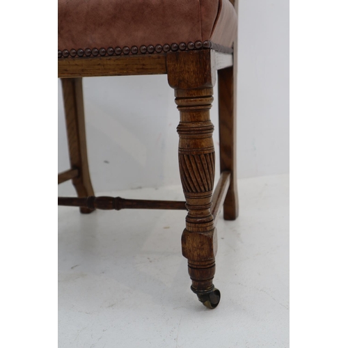 12 - Antique Oak Chair with Faux Leather Covering and Brass Front Castors