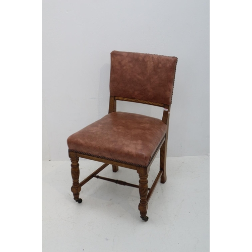 12 - Antique Oak Chair with Faux Leather Covering and Brass Front Castors