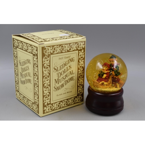 236 - Past Times Sledging Dolls Musical Snow Globe. Complete with box