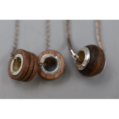 97 - Two Necklaces with wood and Silver Pendants, one marked Blog on Silver Chains