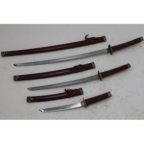 257 - A Set of Three Graduating Katana Swords With Sheaths, In Crimson. On Display Stand. Largest Approx 3... 