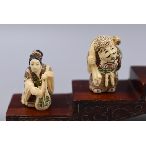 4 - Selection of 7 Oriental Figures Standing on Inlaid Wooden Plinth (12