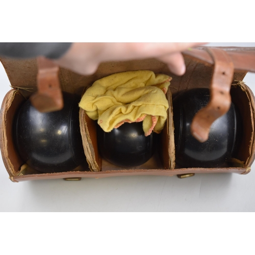 268 - A Set of Three Thomas Taylor Lignoid Lawn Bowls In Leather Carry Case.