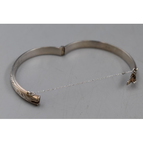 24 - An Etched Hallmarked Birmingham Silver Bangle, With Safety Chain. Circa 1971.