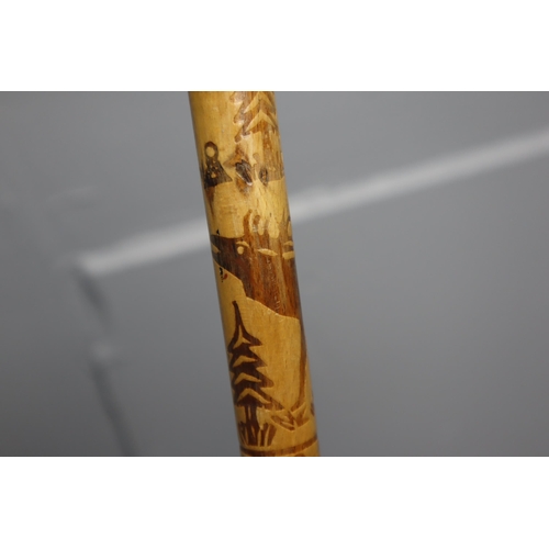 451 - A Native American Axe Head Walking Stick Depicting Woodland Scene, With Animal Skin Bow Body. Walkin... 