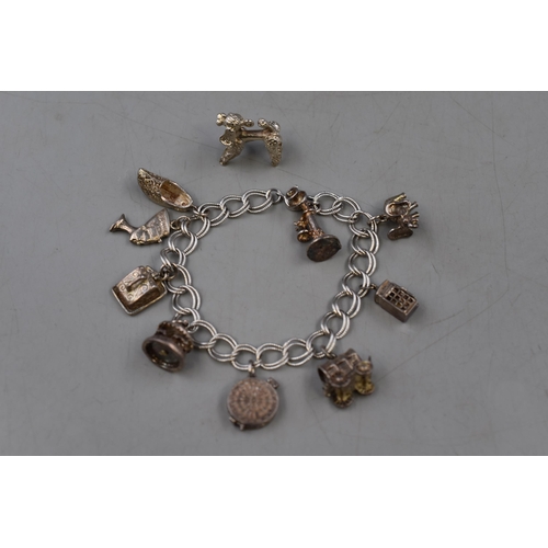 25 - A Sterling Silver Charm Bracelet With a Selection of Silver Charms (Not All Charms are Silver).