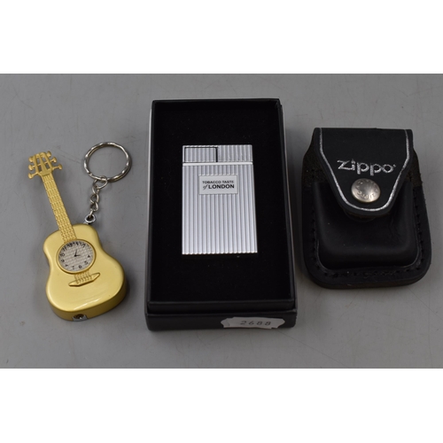 129 - Tobacco Taste of London USB Lighter, Guitar Style Key Ring and a Zippo Belt Case